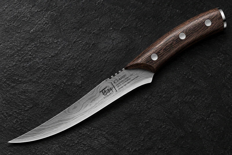 One complete curved pointed patterned boning knife with three silver handle rivets and physical blade markings on textured black stone